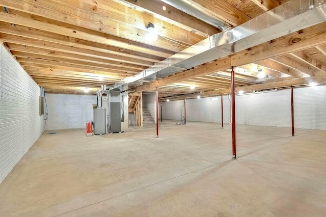 basement with heating unit, brick wall, and water heater