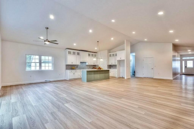 kitchen featuring white cabinets, a center island, light hardwood / wood-style flooring, and pendant lighting