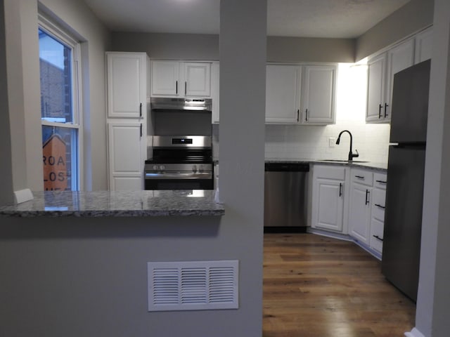 kitchen with white cabinets, refrigerator, sink, stainless steel dishwasher, and range