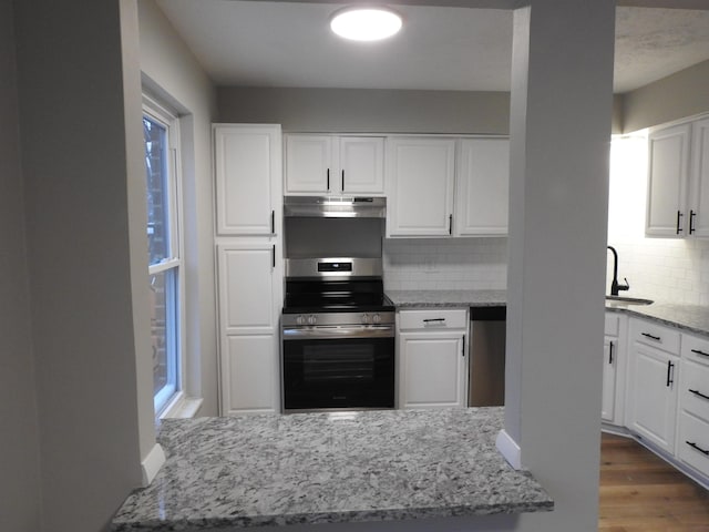 kitchen featuring white cabinets, appliances with stainless steel finishes, and tasteful backsplash