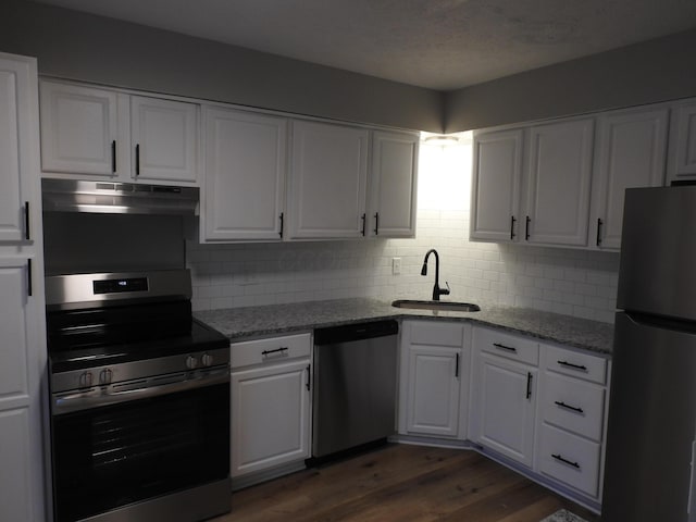 kitchen with white cabinetry, sink, light stone countertops, stainless steel appliances, and tasteful backsplash