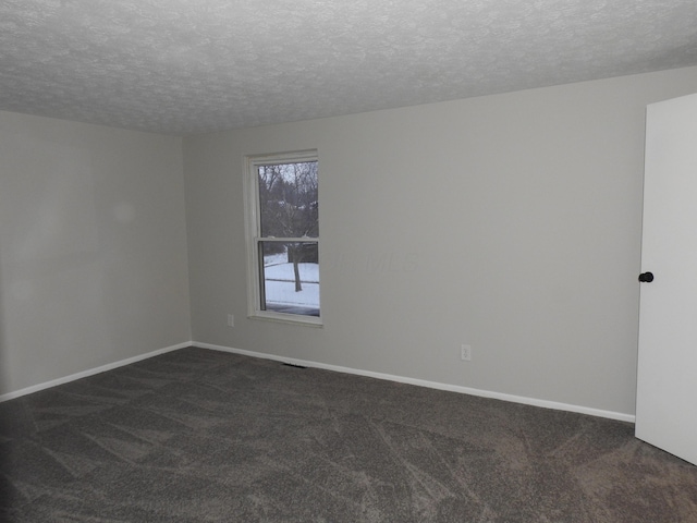 carpeted empty room featuring a textured ceiling