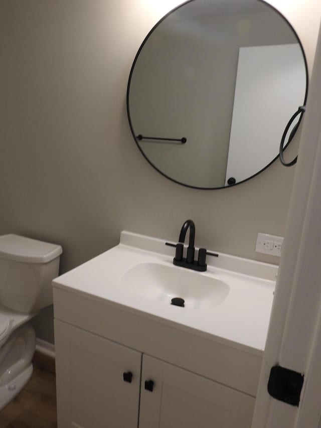 bathroom with hardwood / wood-style flooring, vanity, and toilet