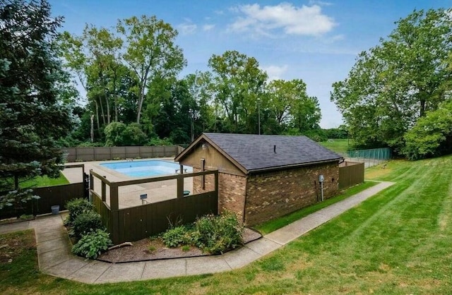 exterior space with a lawn and a fenced in pool