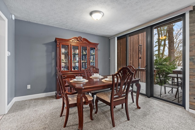 dining space with a textured ceiling and carpet