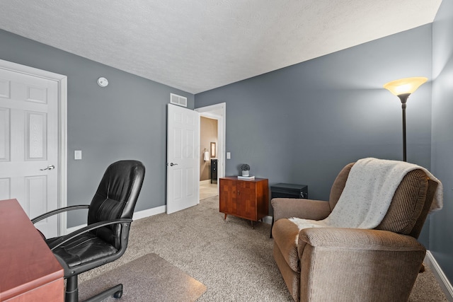 carpeted office space featuring a textured ceiling