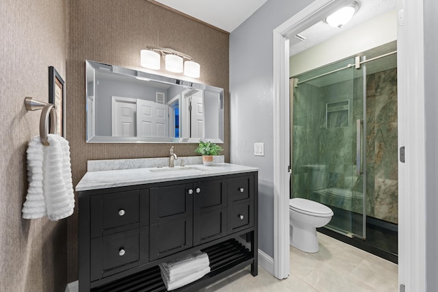 bathroom with toilet, tile patterned flooring, a shower with shower door, and vanity