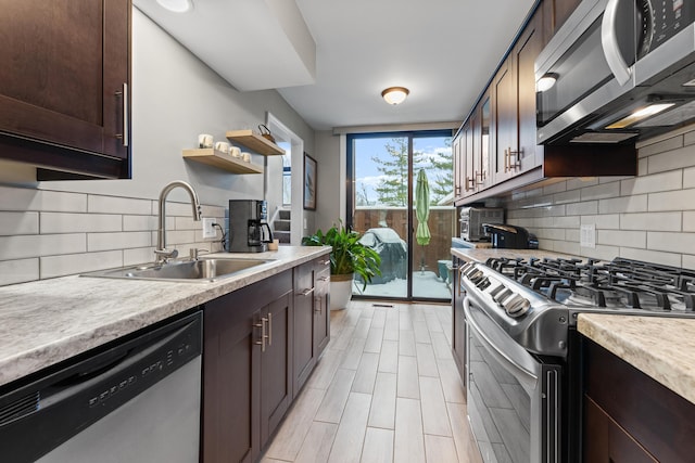 kitchen featuring stainless steel appliances, light wood-type flooring, decorative backsplash, sink, and dark brown cabinets