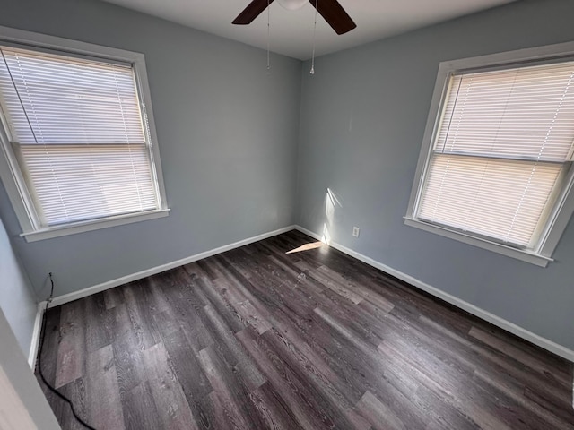 empty room featuring ceiling fan, a healthy amount of sunlight, and dark hardwood / wood-style floors