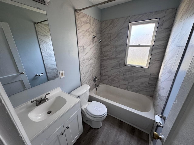 full bathroom featuring vanity, wood-type flooring, tiled shower / bath combo, and toilet