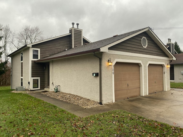 view of side of property with a yard and a garage