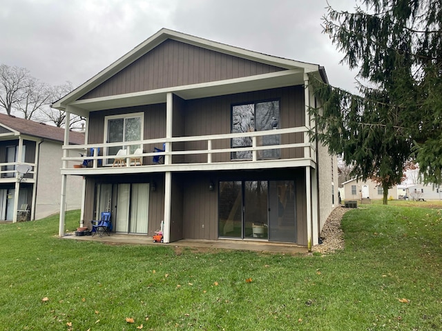 back of house with a yard and a balcony