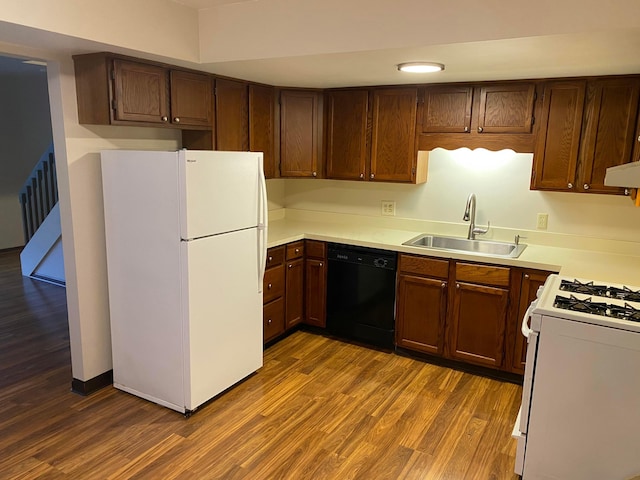 kitchen with hardwood / wood-style floors, white appliances, and sink