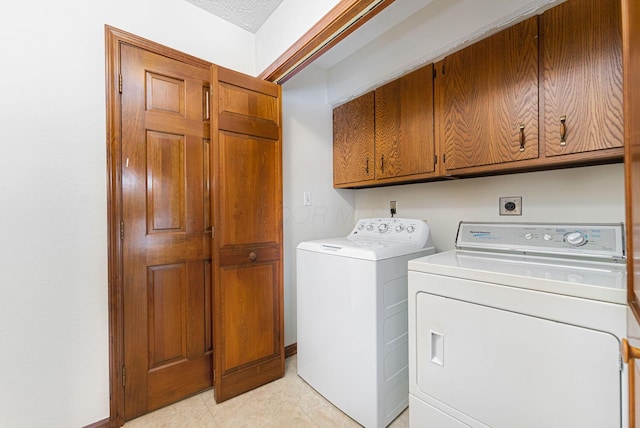 laundry room with washing machine and clothes dryer and cabinets