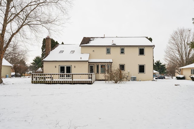 snow covered back of property featuring a wooden deck