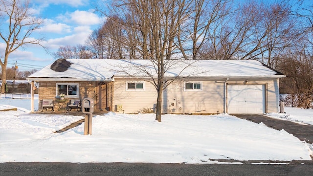 snow covered house featuring a garage