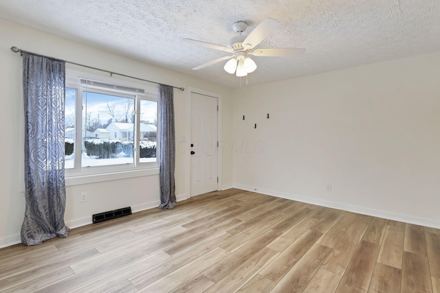 unfurnished room featuring a textured ceiling, light hardwood / wood-style floors, and ceiling fan