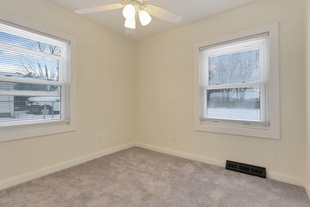 spare room with ceiling fan and light colored carpet