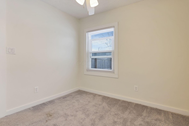 spare room with ceiling fan and light colored carpet