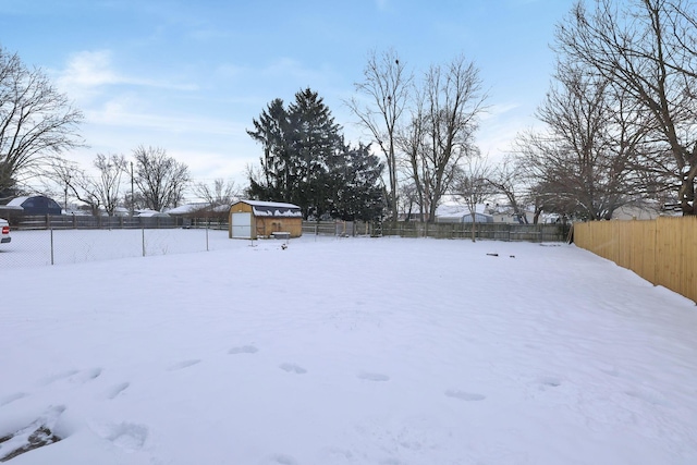 yard covered in snow featuring a shed