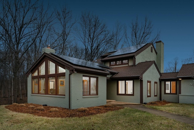 view of home's exterior featuring a lawn and solar panels