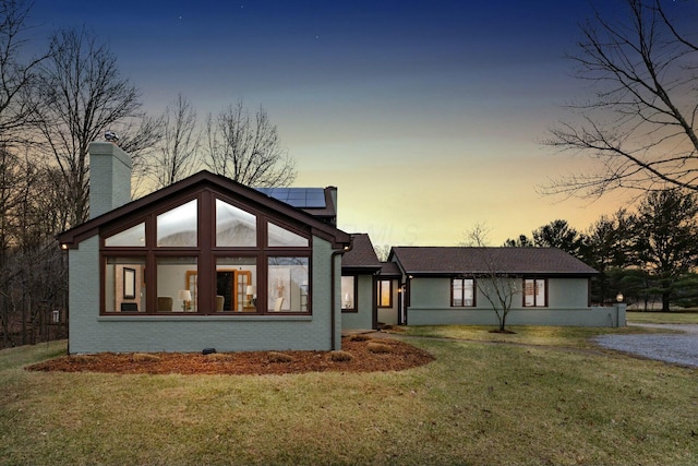 view of front of house with a lawn and solar panels