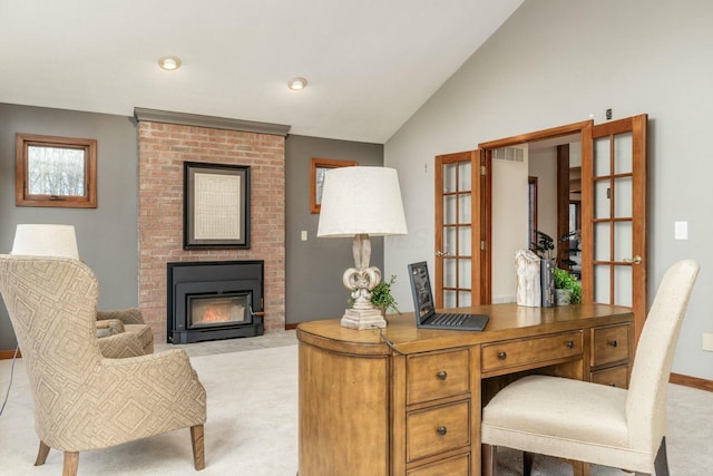 home office with a fireplace, french doors, light colored carpet, and vaulted ceiling