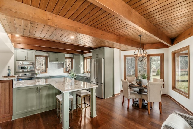 kitchen with hanging light fixtures, light stone countertops, tasteful backsplash, beam ceiling, and stainless steel appliances