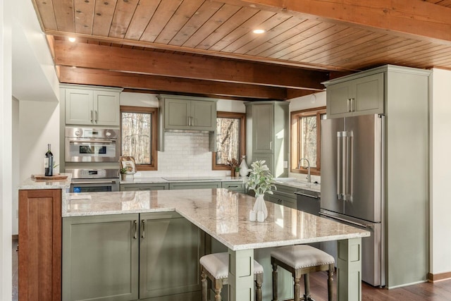 kitchen with light stone countertops, stainless steel appliances, a kitchen island, and wooden ceiling