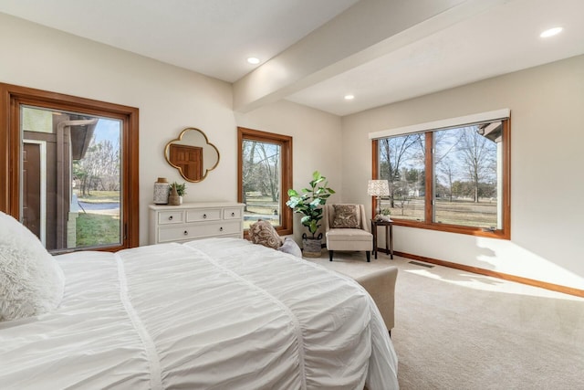 carpeted bedroom with beam ceiling and multiple windows