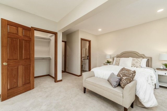 bedroom featuring ensuite bath, a closet, and light colored carpet