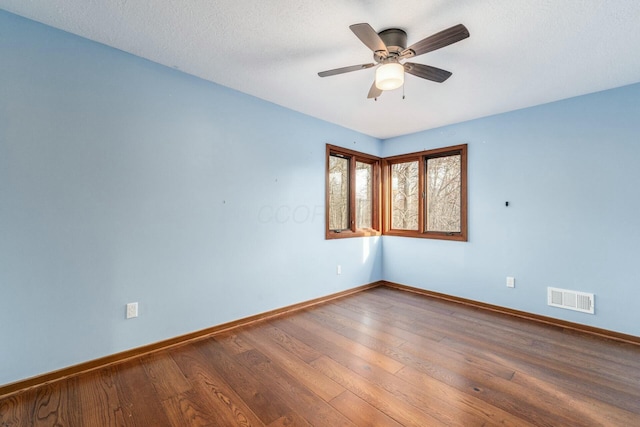 empty room with wood-type flooring, a textured ceiling, and ceiling fan