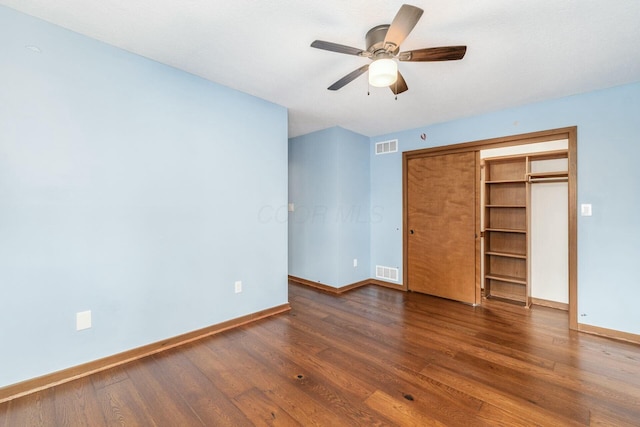 unfurnished bedroom featuring ceiling fan, a closet, and dark wood-type flooring