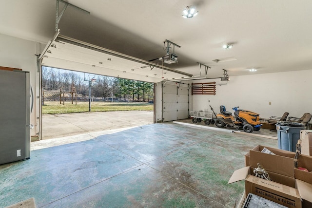 garage with stainless steel fridge and a garage door opener