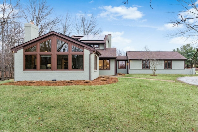 view of front facade featuring solar panels and a front lawn