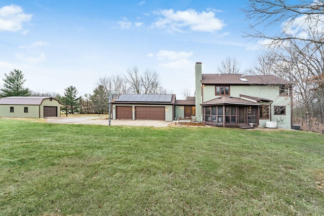 view of yard featuring an outbuilding, a garage, central AC unit, and a sunroom