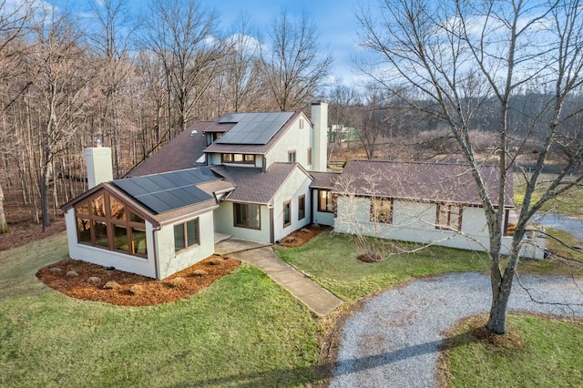 view of front facade with solar panels and a front lawn