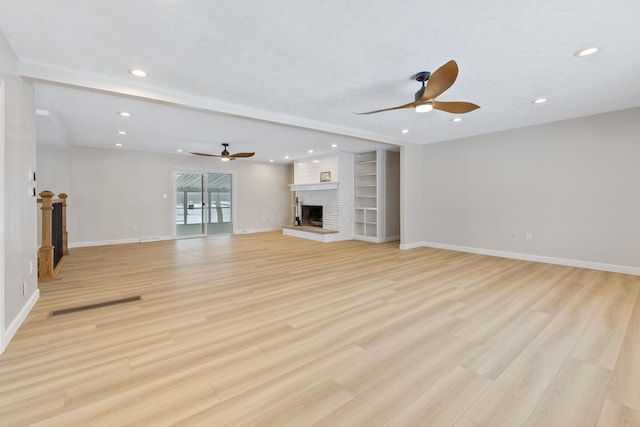 unfurnished living room featuring light hardwood / wood-style floors, a brick fireplace, and ceiling fan