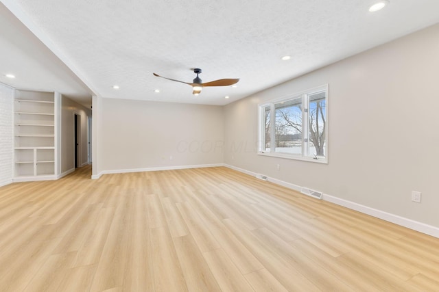 interior space with ceiling fan, built in features, light hardwood / wood-style floors, and a textured ceiling