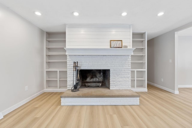 unfurnished living room with hardwood / wood-style flooring and a brick fireplace