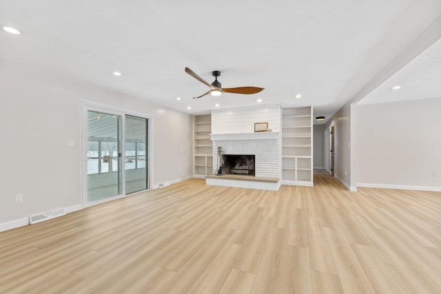 unfurnished living room featuring ceiling fan, light hardwood / wood-style flooring, and a brick fireplace