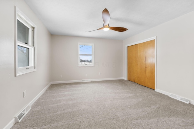 unfurnished bedroom with ceiling fan, a closet, and carpet