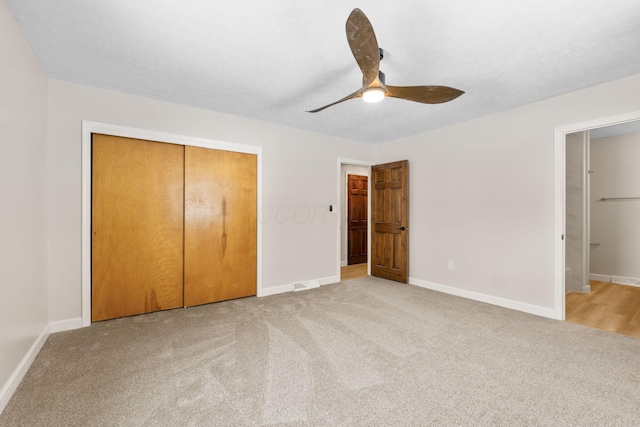 unfurnished bedroom with carpet flooring, ceiling fan, and a closet