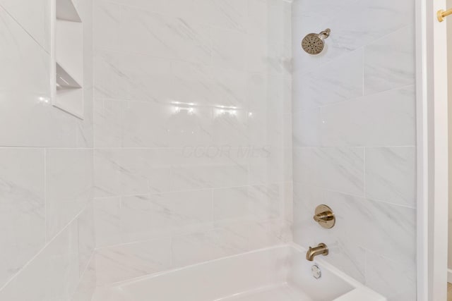 bathroom featuring tiled shower / bath