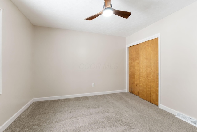 carpeted spare room with ceiling fan