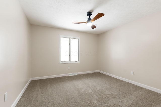 carpeted spare room featuring ceiling fan and a textured ceiling