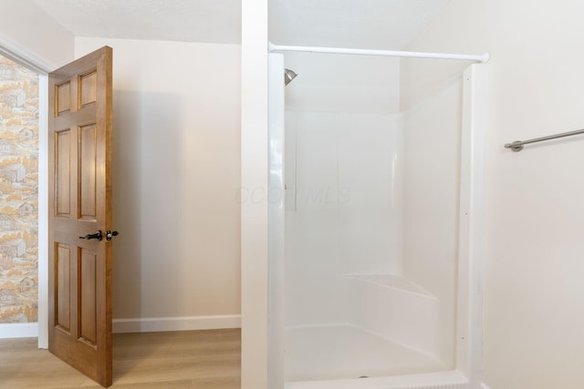 bathroom with wood-type flooring and walk in shower