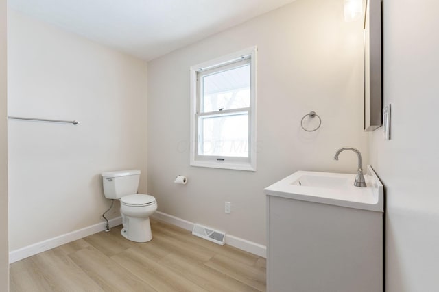 bathroom featuring hardwood / wood-style floors, vanity, and toilet