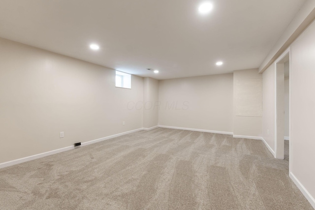 basement featuring light colored carpet