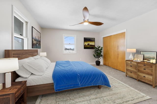 bedroom with ceiling fan, a closet, and light colored carpet